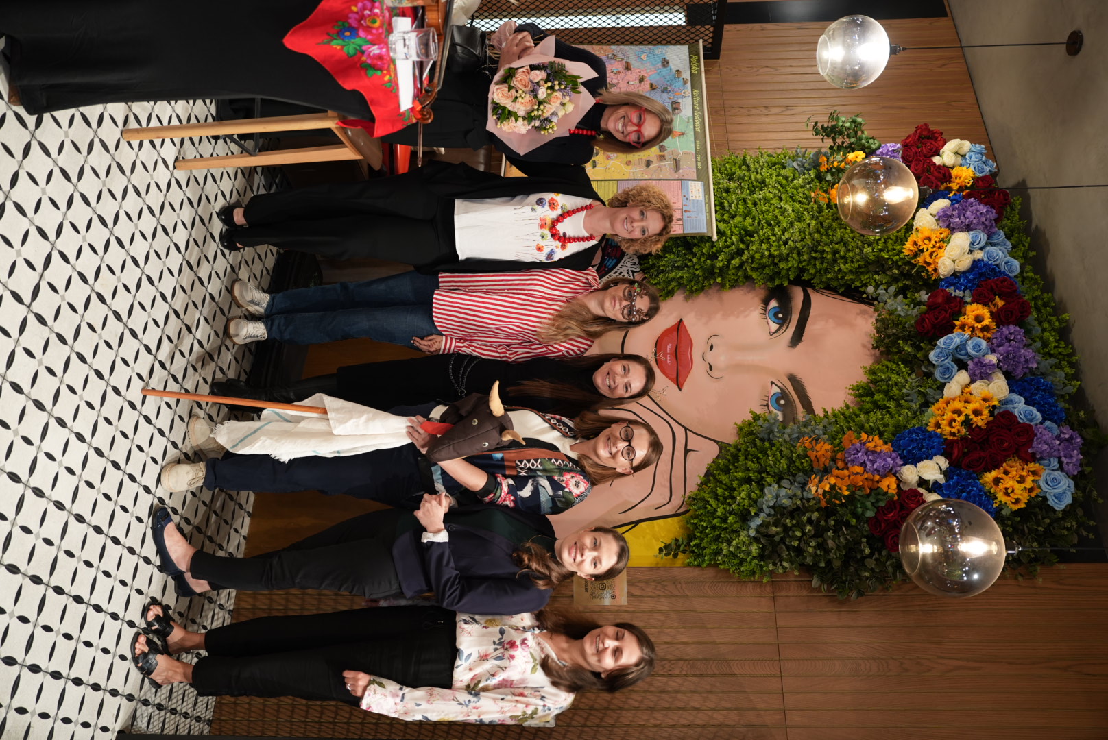 Guests gathered at a Polka event by the floral mural
